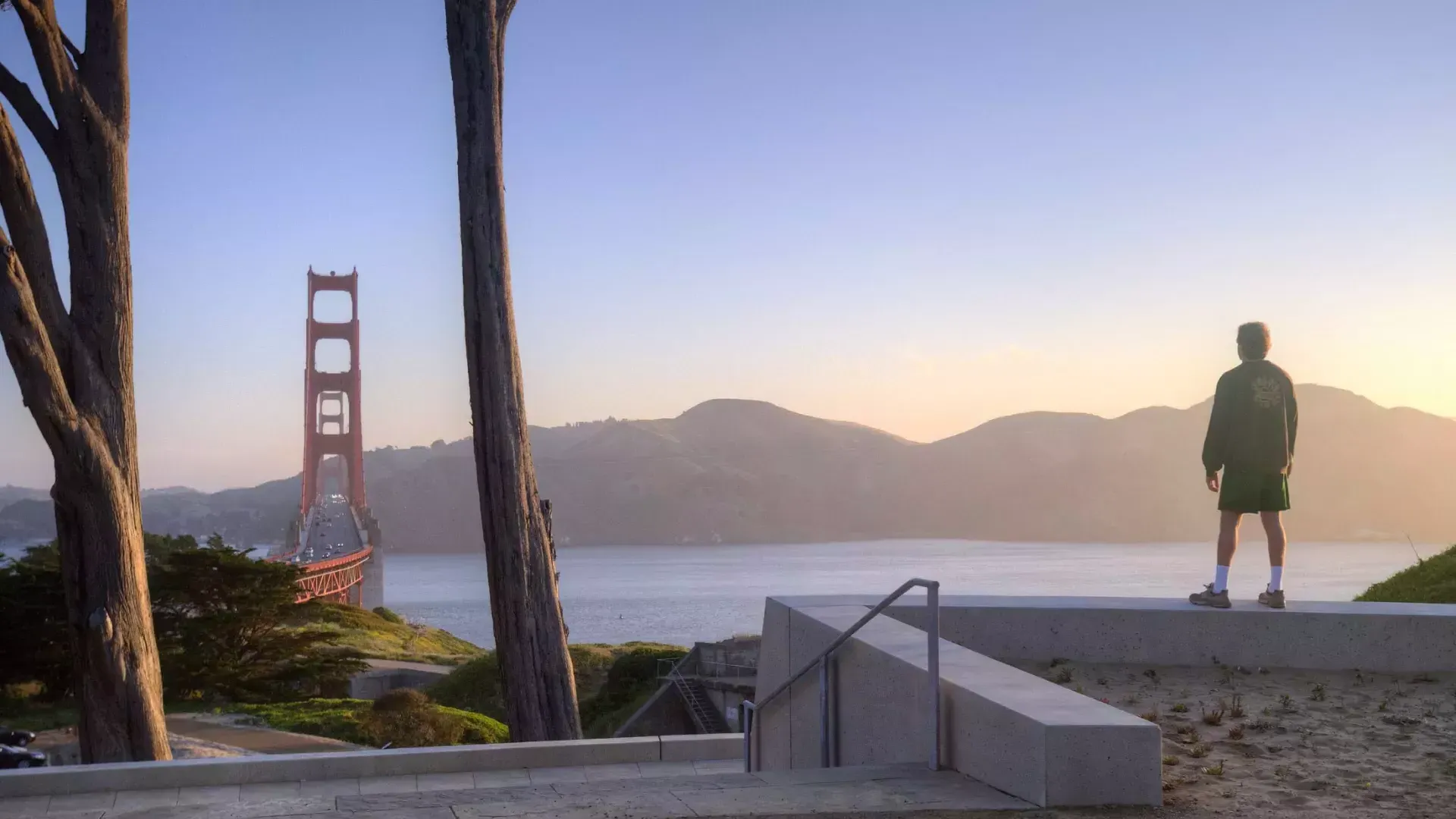 Ein Mann blickt auf die Golden Gate Bridge mit Bergen im Hintergrund.