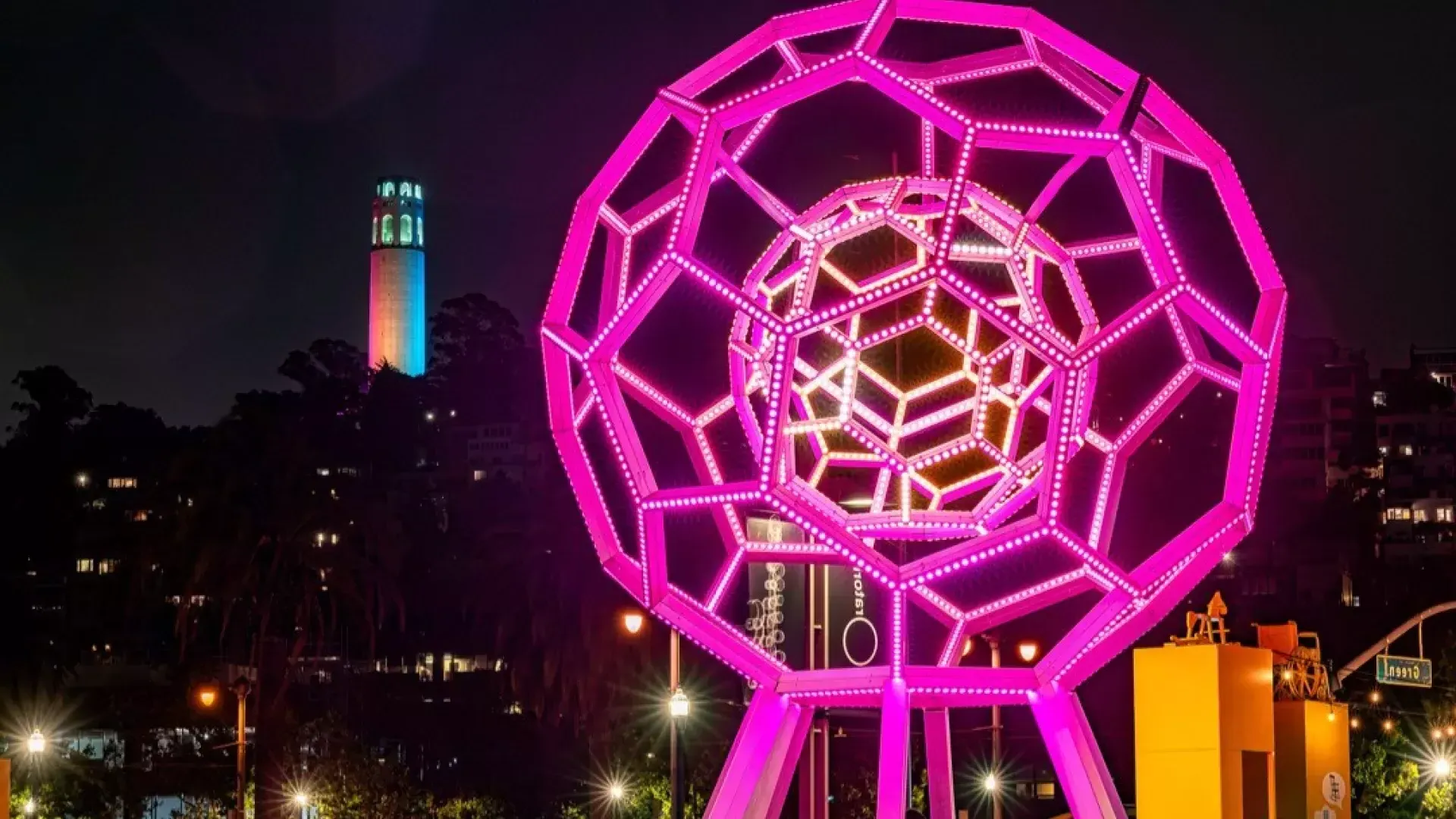 Buckyball brille à l'extérieur de l'Exploratorium, avec la Coit Tower en arrière-plan