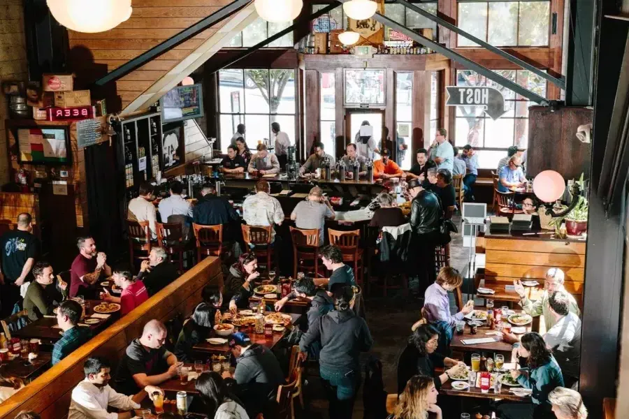 I clienti mangiano e bevono all'interno della 21st Amendment Brewery di San Francisco.