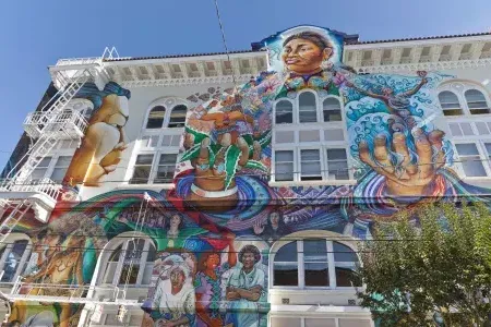 Ein farbenfrohes, großformatiges Wandgemälde bedeckt die Seite des Women's Building im Mission District von San Francisco.