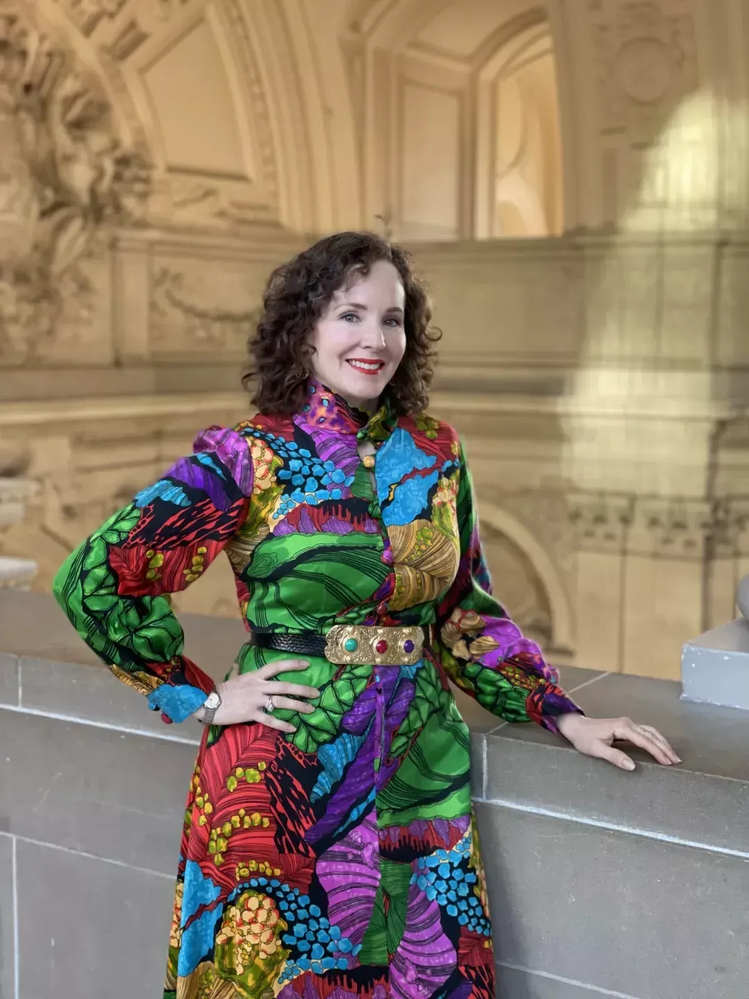 Kate Patterson posing in a colorful dress inside City Hall. 